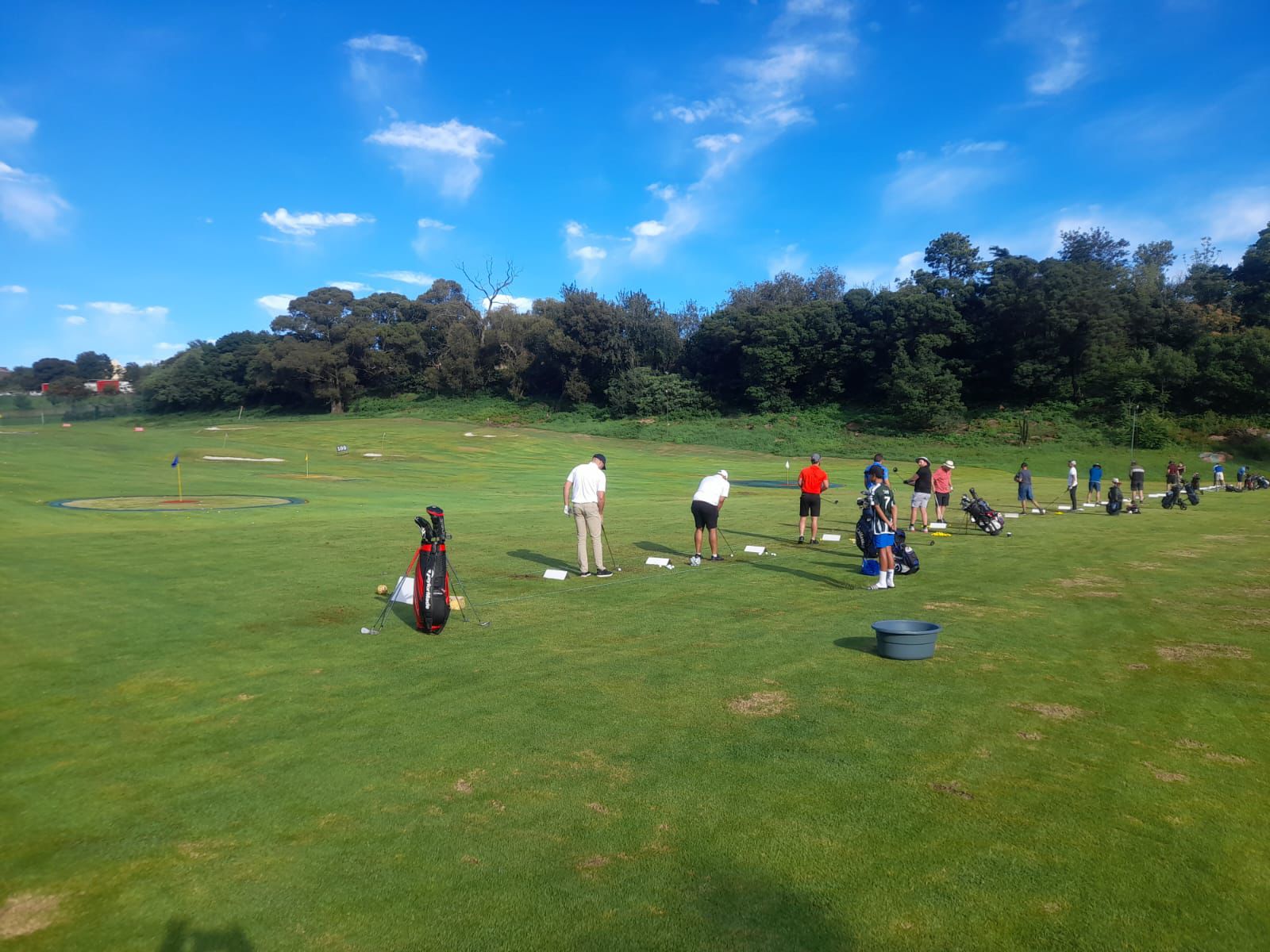 Golfers practicing on the real grass tee line